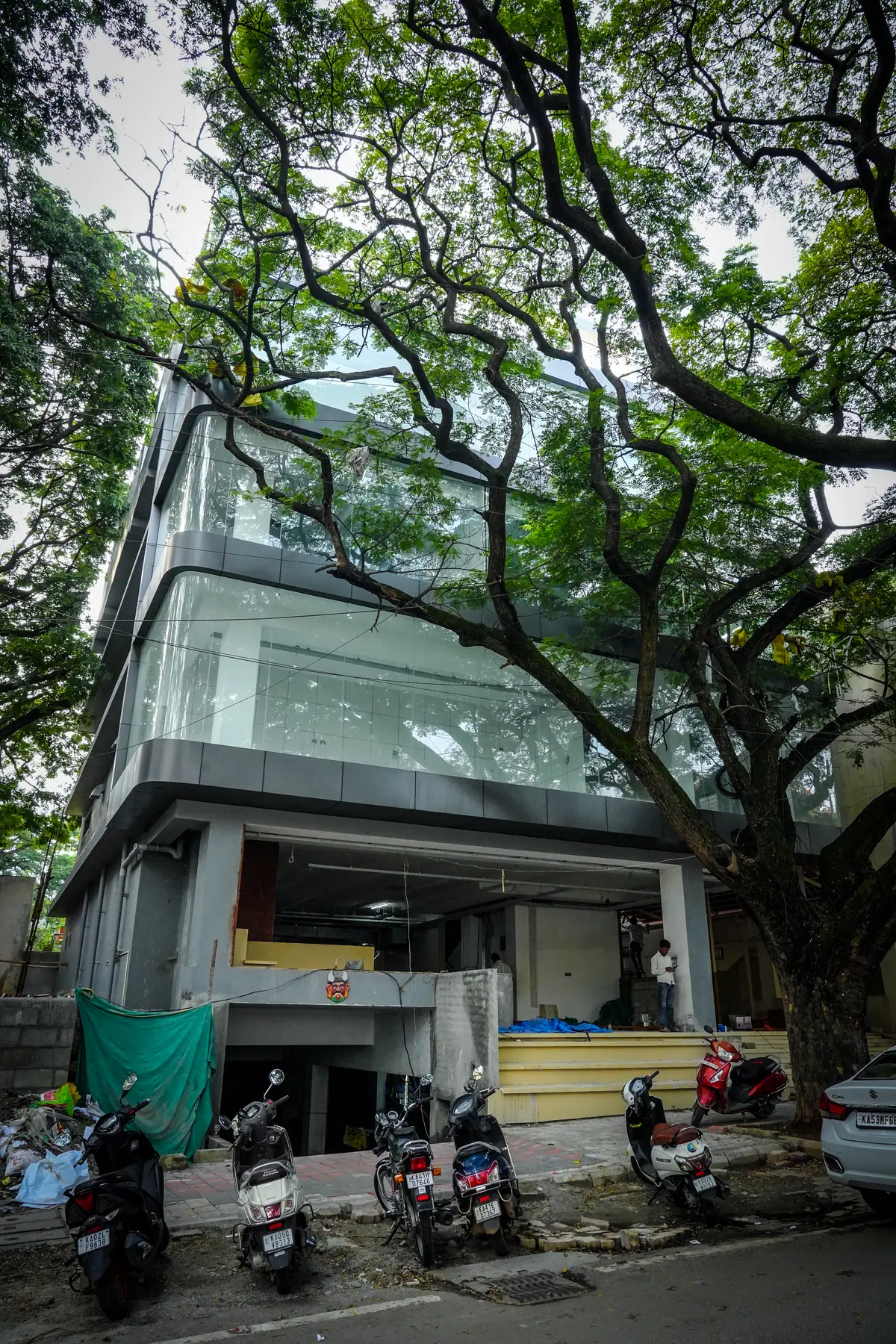 Glass-fronted Urban Premium Coworks building seen through a large tree