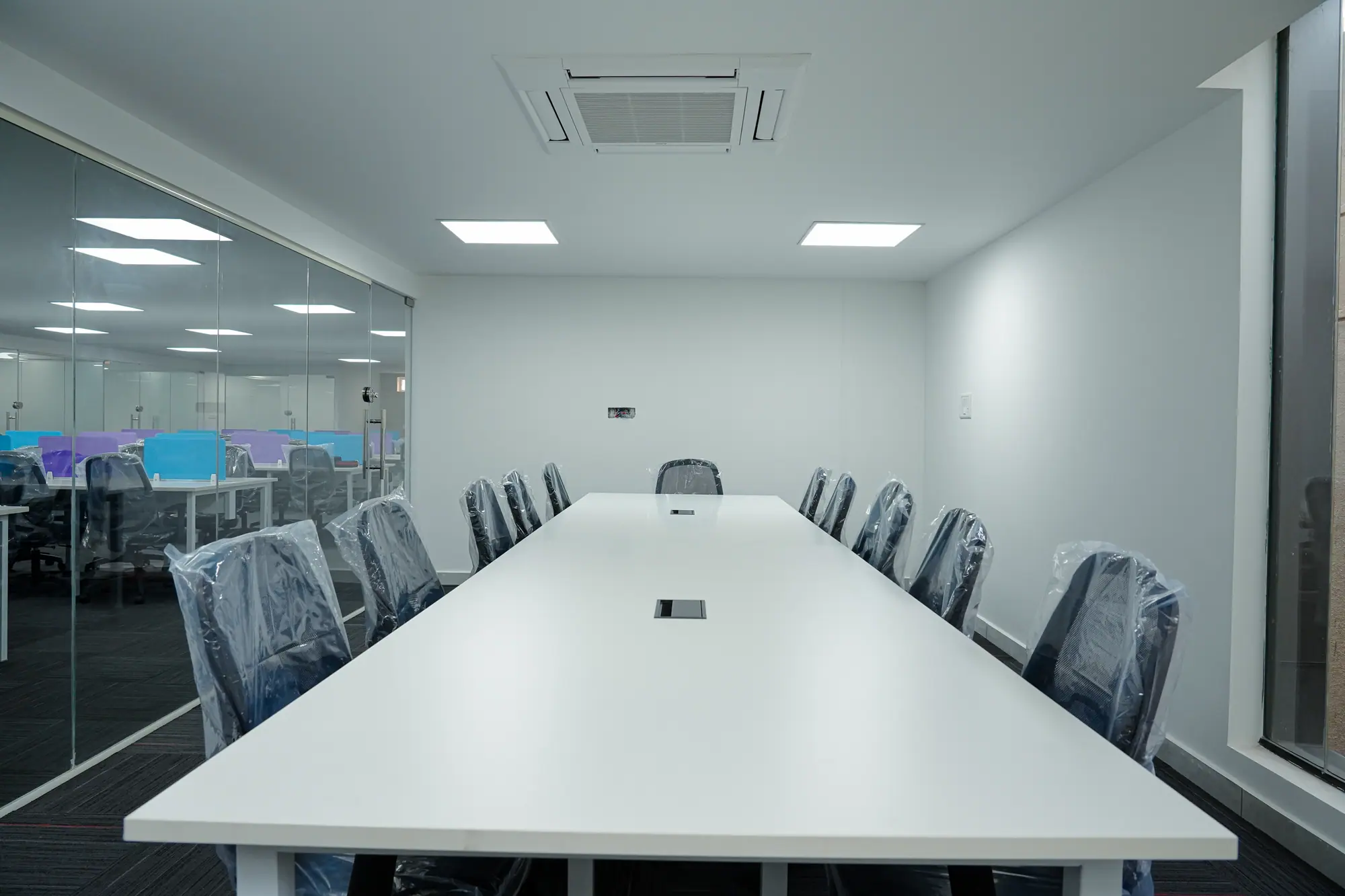 Glass-walled meeting room with a long white table