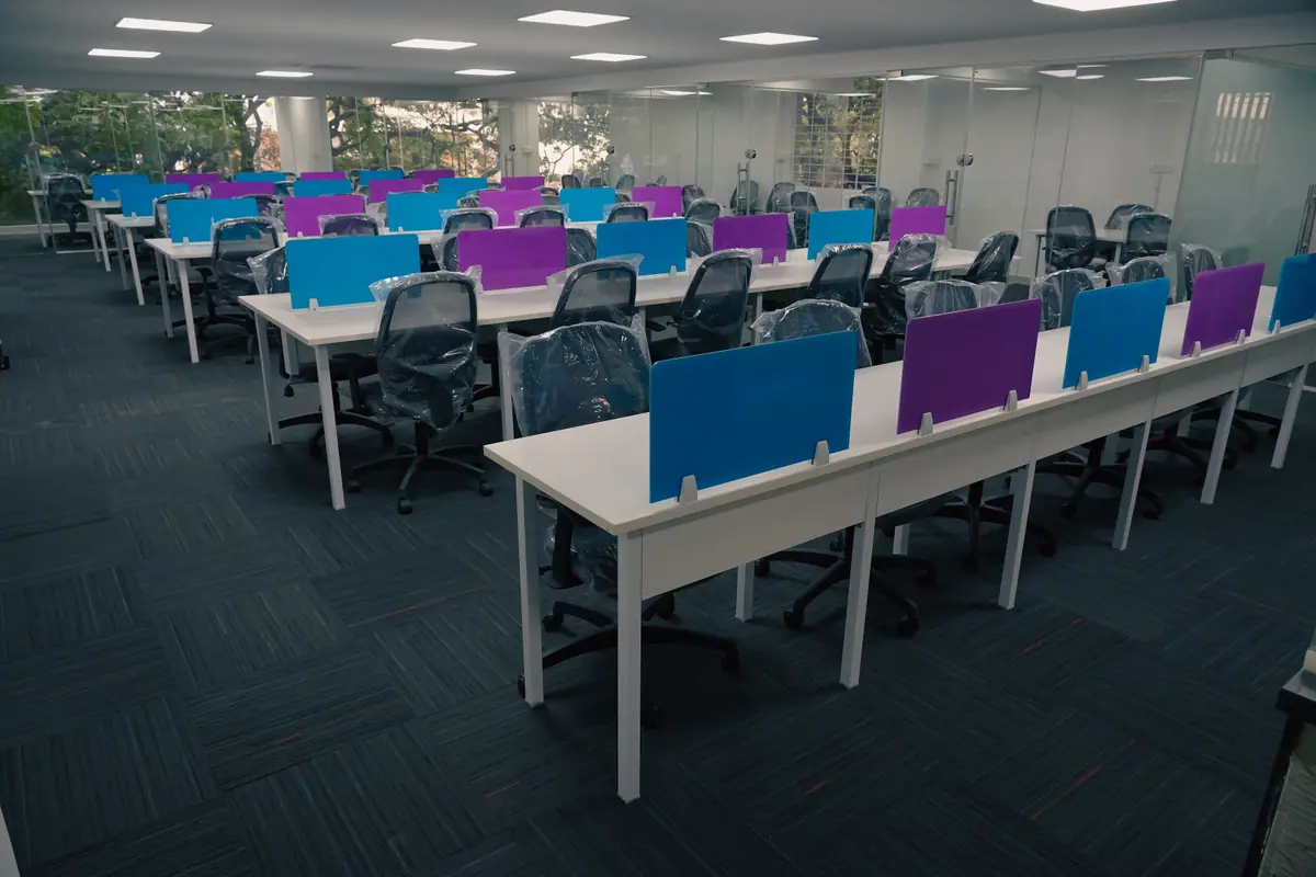 The Commons open desk area with rows of white desks and coloured partitions