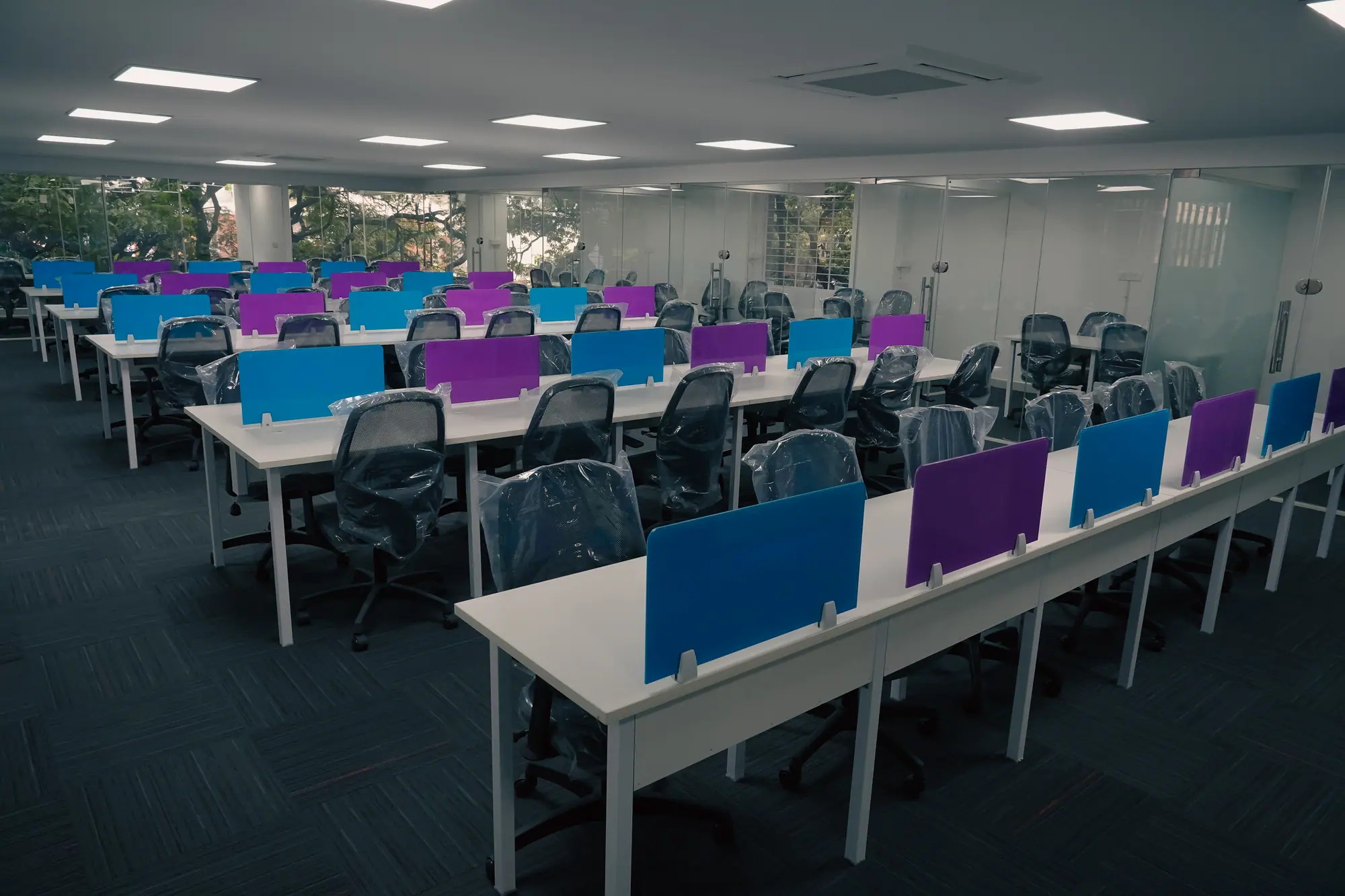 Open desk area stretching toward floor-to-ceiling windows