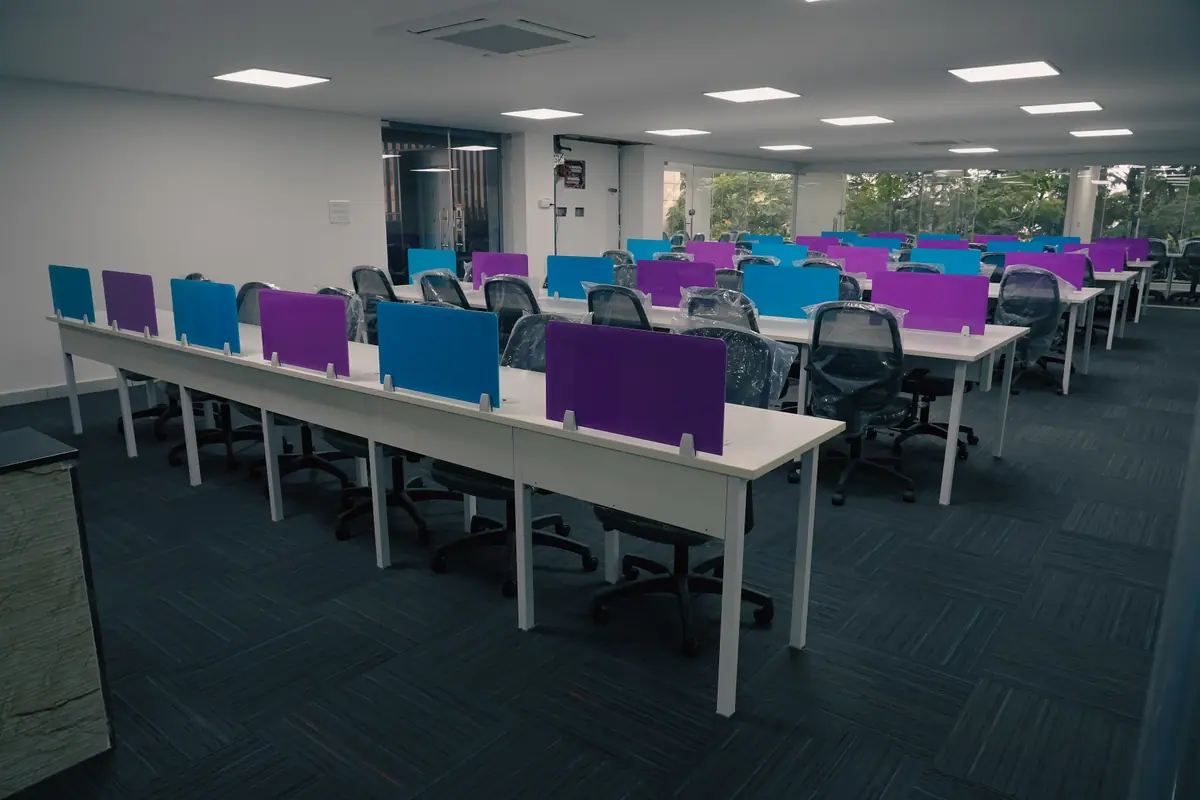 Long white desks with blue and purple partitions in the open workspace