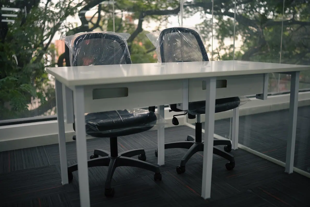 Dedicated desk with storage drawers in front of a tree-lined window
