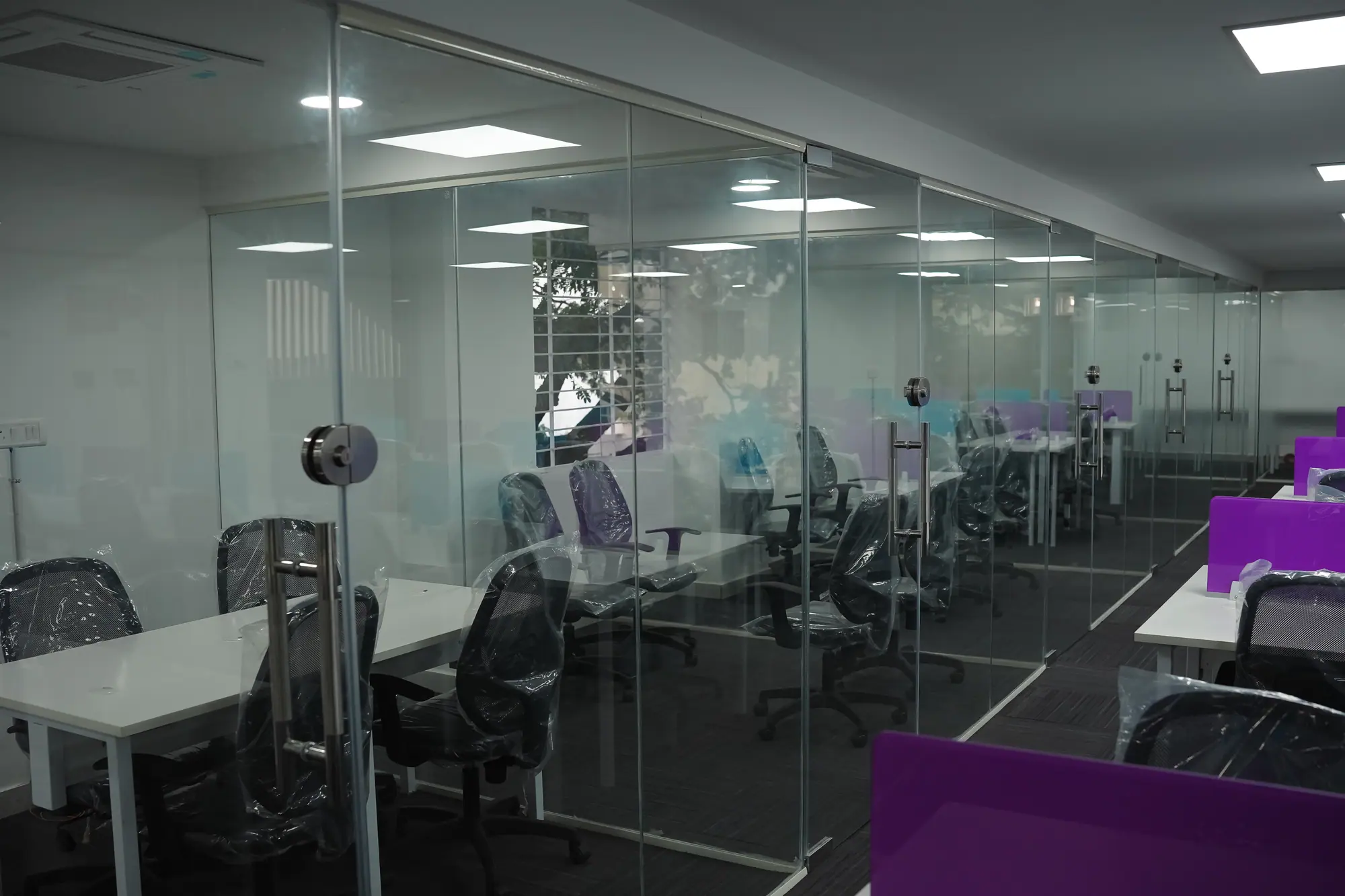 Glass-walled cabins looking across the open workspace